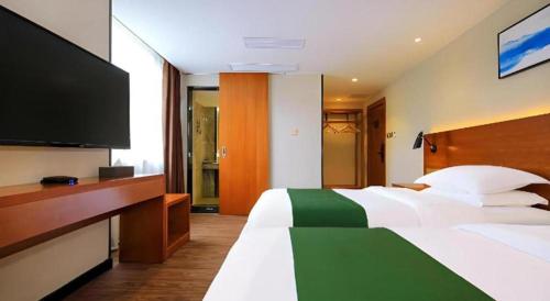 a hotel room with a bed and a flat screen tv at Immersing Hotel Guilin Two Rivers and Four Lakes Dongxi Alley in Guilin