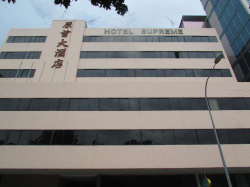 a tall building with a clock on the front of it at Hotel Supreme in Singapore