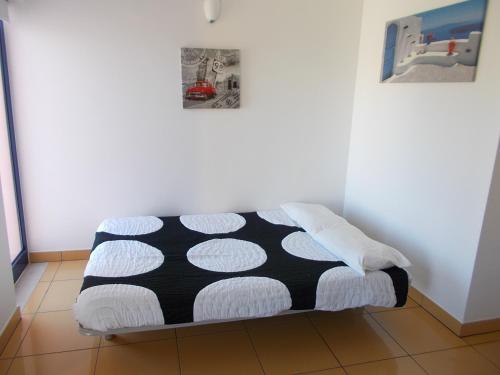 a bed in a room with a black and white blanket at T1 e T2 Marina Albufeira apartments in Albufeira