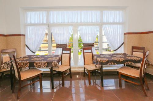 a dining room with two tables and chairs and a window at Willa Saga in Władysławowo