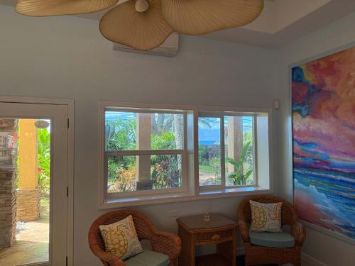 a living room with two chairs and two windows at Half Off Bed & Breakfast Suite Steps from Beach with AC in Napili-Honokowai