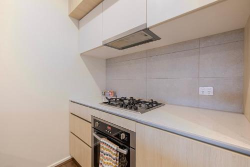 a kitchen with a stove top oven next to a counter at Modern Family Retreat in Point Cook and Free Parking in Point Cook