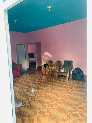 a living room with chairs and a purple wall at Casa el Marinero in Monterrico