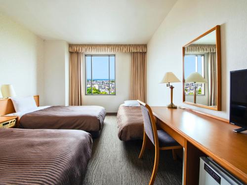 a hotel room with two beds and a desk at Hotel Concorde Hamamatsu in Hamamatsu