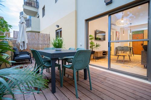 a patio with a table and chairs on a deck at Almogim Suites Eilat Hotel in Eilat