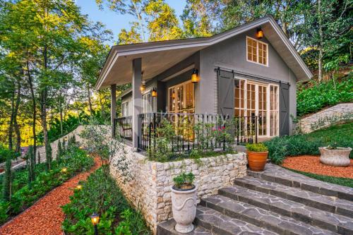 a small house with a stone wall at Taman Wisata Bougenville by Kozystay in Malabar