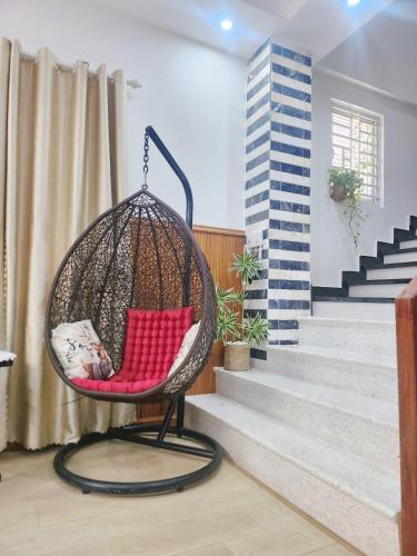 a swing chair in a living room with stairs at Nguyên căn 4 giường YA Beach Da Nang in Da Nang