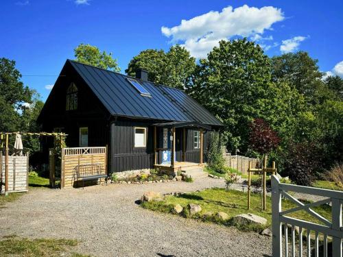 a black house with a black roof at Design House With Garden In The Heart Of Småland in Gullabo