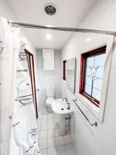 a white bathroom with a sink and a toilet at Central Castlemaine studio on steam train line in Castlemaine