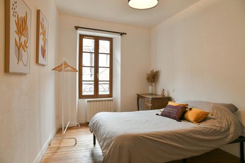 Charmant T4 Centre-ville, Lacs et Montagnes في Le Pont-de-Beauvoisin: غرفة نوم بها سرير ونافذة