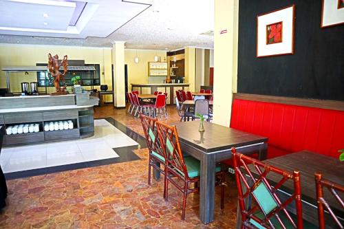 a dining room with a table and chairs at PLUM Prestige Hotel Juanda in Kalangan