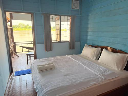 a bedroom with a large bed with a blue wall at Namknong view in Don Det