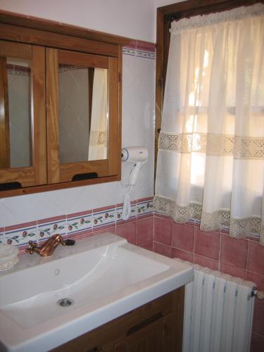 a bathroom with a sink and a mirror and a window at Hotel de Montaña Cueva Ahumada in Villaverde de Guadalimar