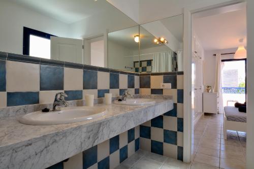 a bathroom with two sinks and a mirror at Villa Oasis in Playa Blanca