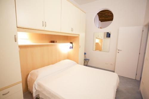 een kleine slaapkamer met een wit bed en witte kasten bij Appartamento Piazza Il Fico in Portoferraio