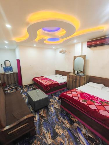 a room with two beds and a painting on the ceiling at Hotel Parinay Vatika - Deoghar in Deoghar