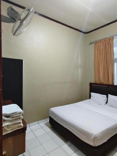 a bedroom with a large bed and a window at Sapadia Hotel Parapat in Parapat