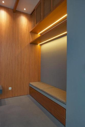a walk in closet with a bench and lights at Wasabi House, Kota Baru Parahyangan in Gantungan