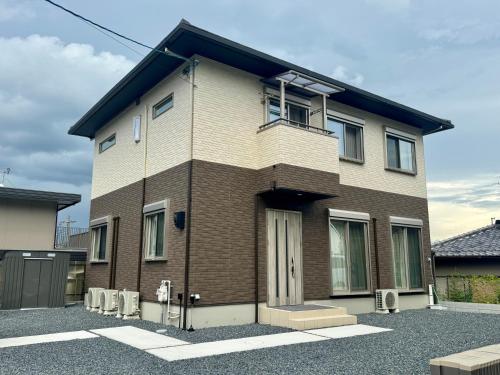 a brown and white brick house with a balcony at 嘉翔の家 in Otsu
