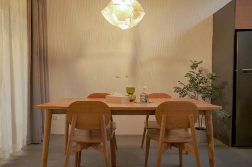 a dining room table with two chairs and a light fixture at Wasabi House, Kota Baru Parahyangan in Gantungan