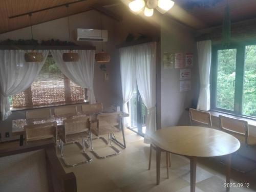ein Esszimmer mit Tisch und Stühlen in der Unterkunft ファミーユグループ城ケ崎店 空音sorane in Ito