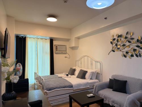 un salon avec un lit et un canapé dans l'établissement Condo in 8 ADRIATICO for Short-stay near UP Manila St Lukes & US Embassy, à Manille