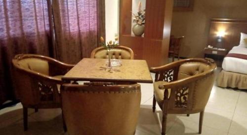 a room with a table and chairs and a bed at Garuda Hotel Pontianak in Pontianak