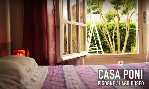 a bedroom with a bed and a window with a view at Casa Poni in Pisogne