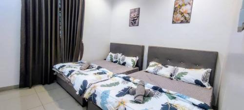 two beds sitting next to each other in a bedroom at Aloha Homestay 18pax Hutan Melintang in Hutan Melintang