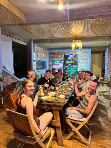 a group of people sitting at a long table at An An Homestay Bungalow in Phong Nha