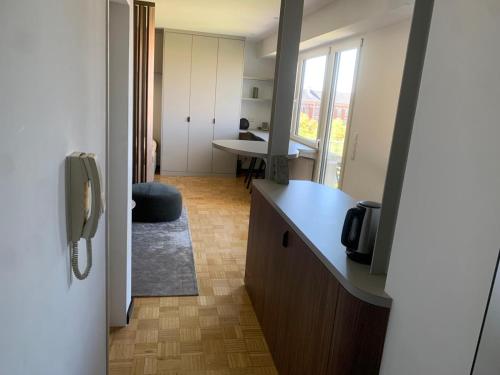 a room with a kitchen with a counter and a phone at Core Luxembourg City - Schuman in Luxembourg