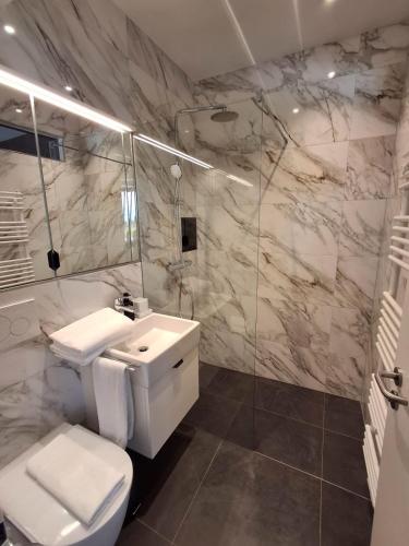 a bathroom with a toilet and a sink and a shower at Core Luxembourg City - Schuman in Luxembourg