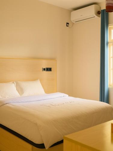 a bedroom with a white bed with a window at Scuba Haven Fuvahmulah in Fuvahmulah