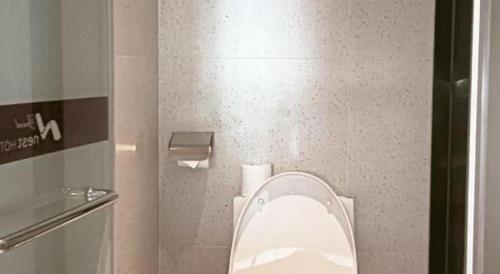 a bathroom with a toilet with the lid up at Grand Nest Hotel (Tang Jia Wan Beach) in Zhuhai