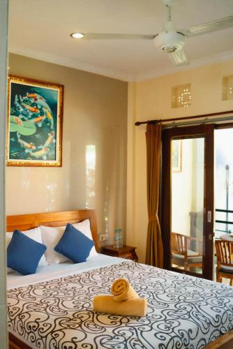 a bedroom with a bed with a towel on it at Uma Taman House in Ubud