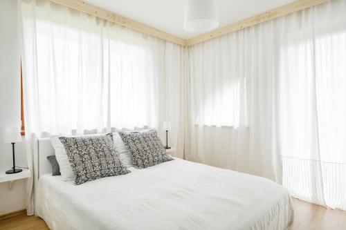 コシチェリスコにあるApartament Krywań Kościeliskoのベッドルーム(白いカーテン付きの白いベッド1台付)