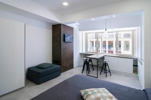 um quarto com uma cama, uma secretária e uma mesa em Relais Castel Nuovo em Nápoles