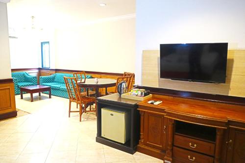 a living room with a large flat screen tv at PLUM Prestige Hotel Juanda in Kalangan