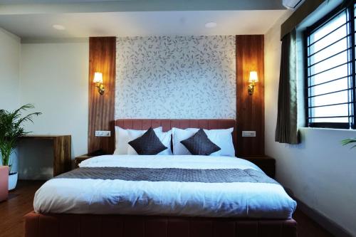 a bedroom with a large bed in a room at Hotel Asilo Prime in Indore