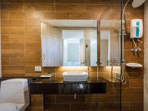 a bathroom with a sink and a toilet and a mirror at Chatnipa Beach Resort in Rayong