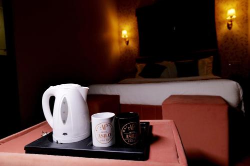 a tray with two cups on a table in a hotel room at Hotel Asilo Prime in Indore