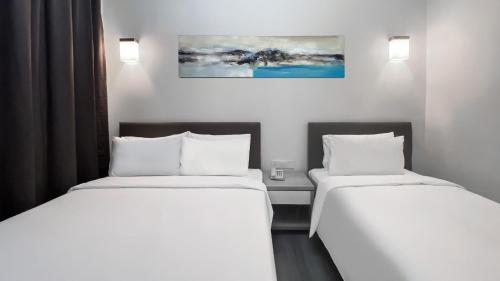 two beds sitting next to each other in a room at Amansari Hotel Nusajaya in Nusajaya