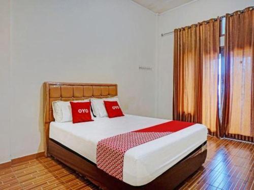 a bedroom with a large bed with red pillows at Hotel O Bontotangnga Homestay in Balangberu