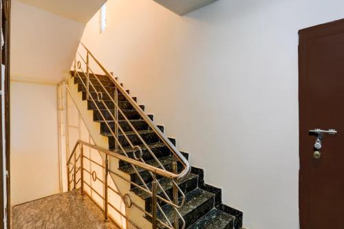 a staircase in a building with a metal railing at Hotel O Kogilu Bus Terminal Formerly Peaceful Stay in Yelahanka