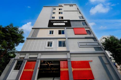 um prédio alto com janelas vermelhas e uma placa nele em Super Townhouse Oak Premier Raidurg Biodiversity Park em Madhapur