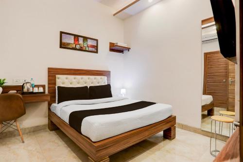 a bedroom with a large bed and a desk at Super Collection O Haldwani Railway Junction Formerly Hotel Kanta in Haldwāni