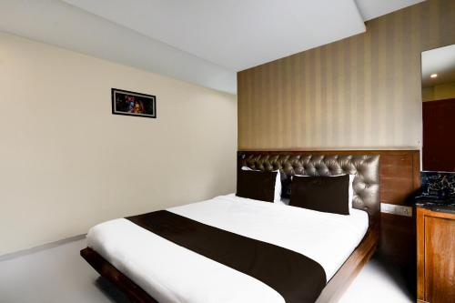 a bedroom with a large bed with a leather headboard at Super Townhouse Kothapet Formerly Surabhi Elite in Surūrnagar