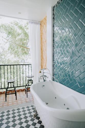 a bathroom with a tub and a checkered floor at G Boutique Resort - Santander in Santander