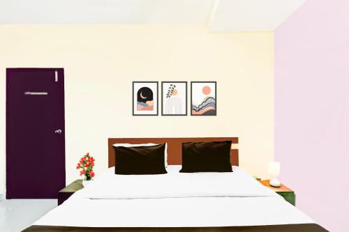 a bedroom with a bed and pictures on the wall at Super Hotel O LB Nagar Metro Station Formerly Virat residency in Surūrnagar