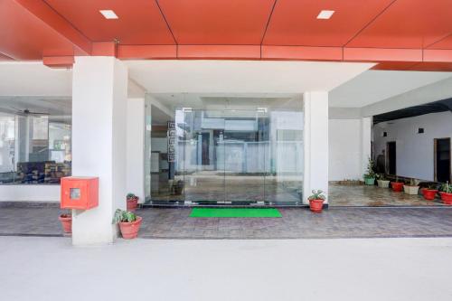 an empty lobby with plants in a building at Super Townhouse Bela Road Varanasi City Railway Station Formerly Srijan Grand in Varanasi